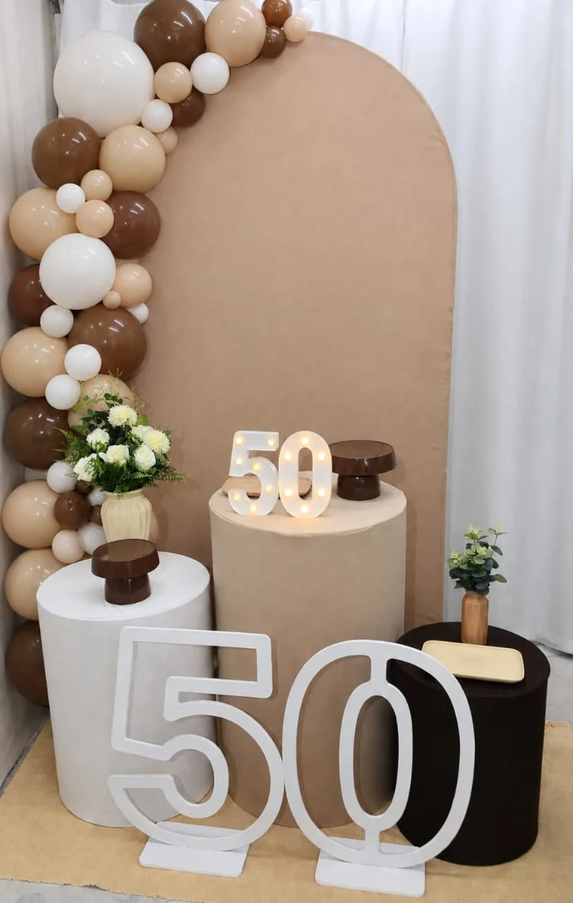 Montagem da Si Faz Festas para 50 anos com painel bege e balões
