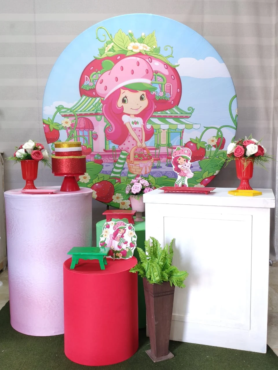 Kit da Si Faz Festas com painel Moranguinho, mesas e detalhes em rosa, verde e amarelo